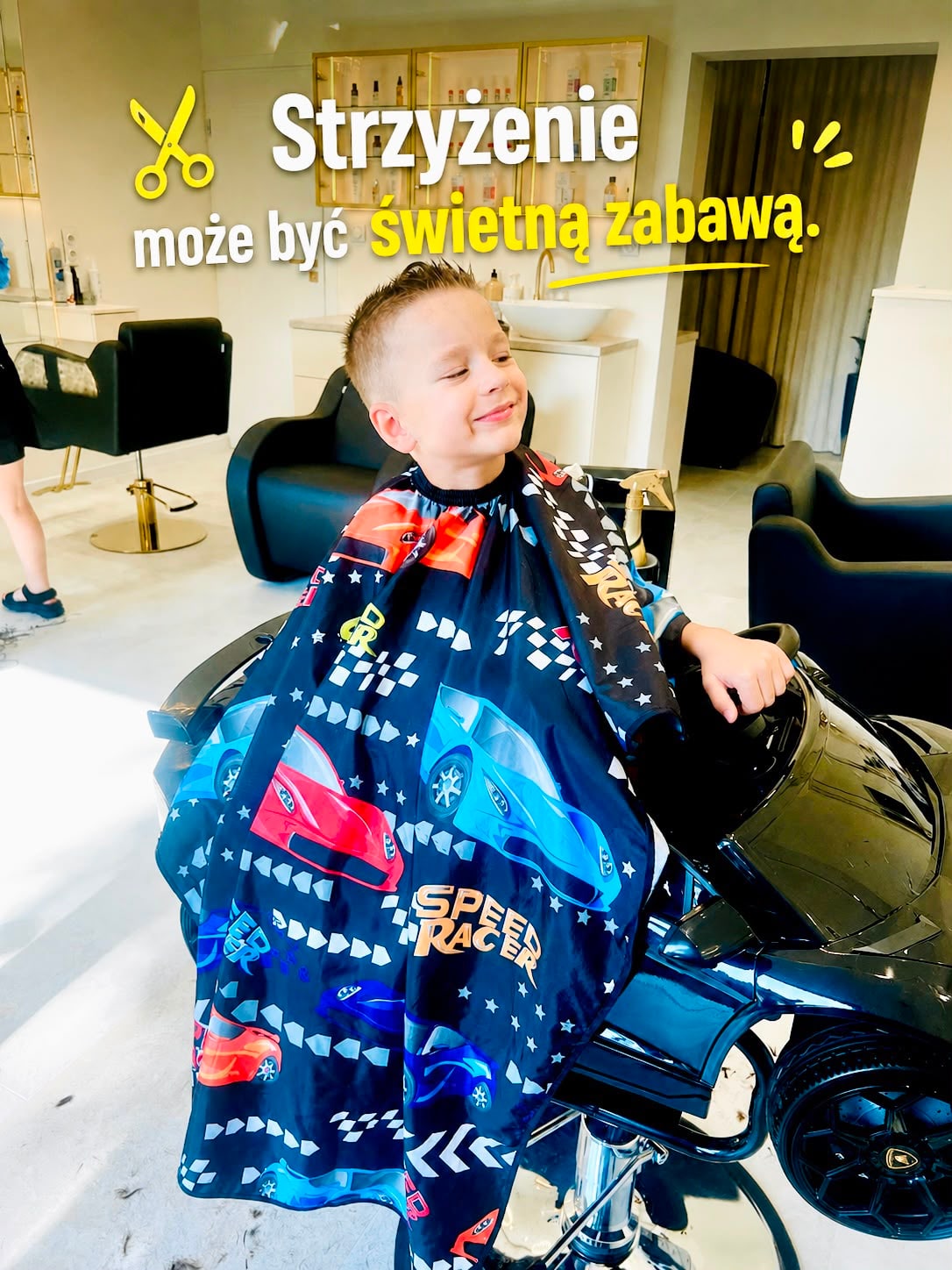 Chłopiec podczas strzyżenia w fotelu w kształcie samochodu.